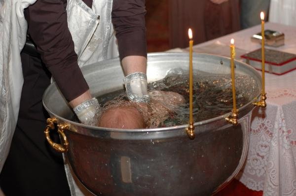 Трехкратное погружательное крещение младенца в купели