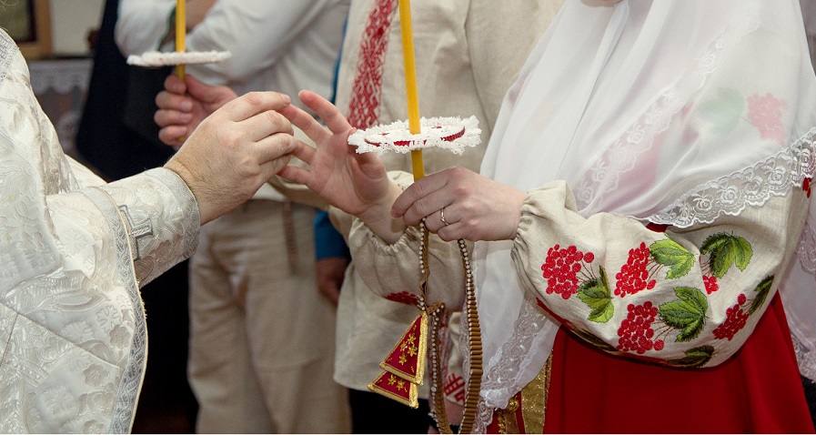 Священник надевает кольца каждому на безымянный палец правой руки 