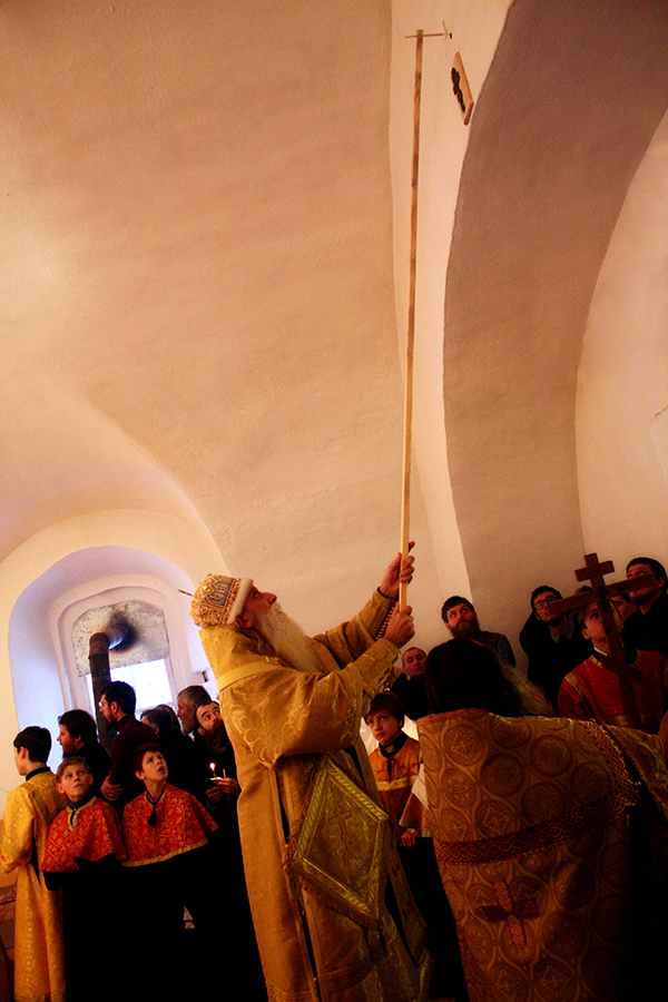 Митрополит Корнилий освященным маслом крестообразно помазывает внутренние стены храма