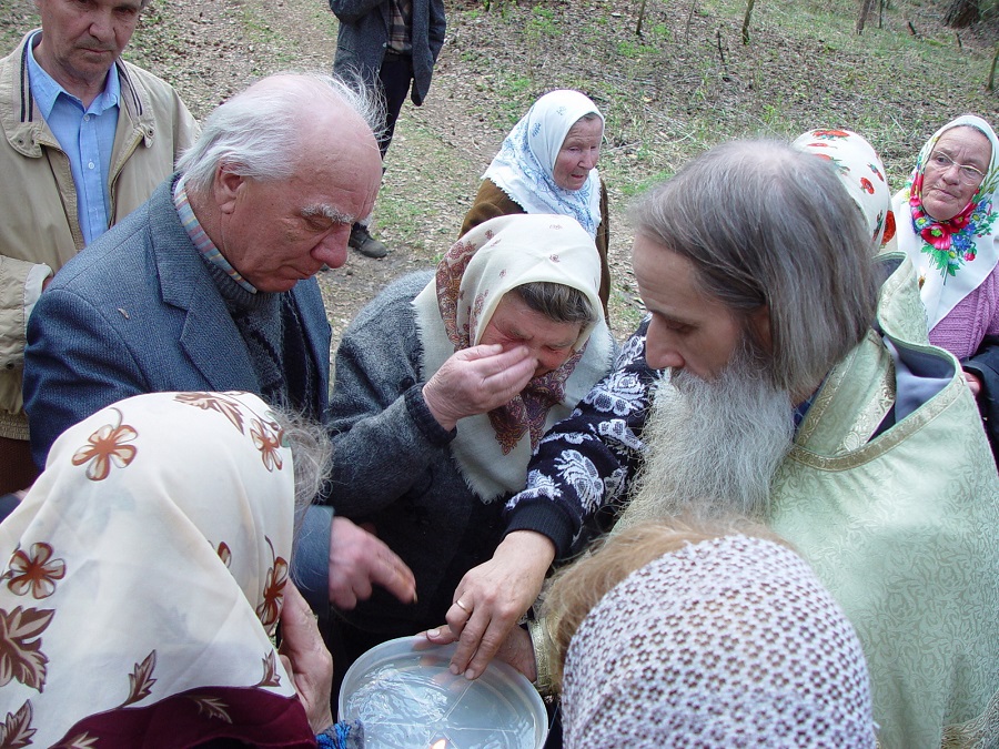 Иерей Константин Титов раздает святую воду после молебна у беливских скитов