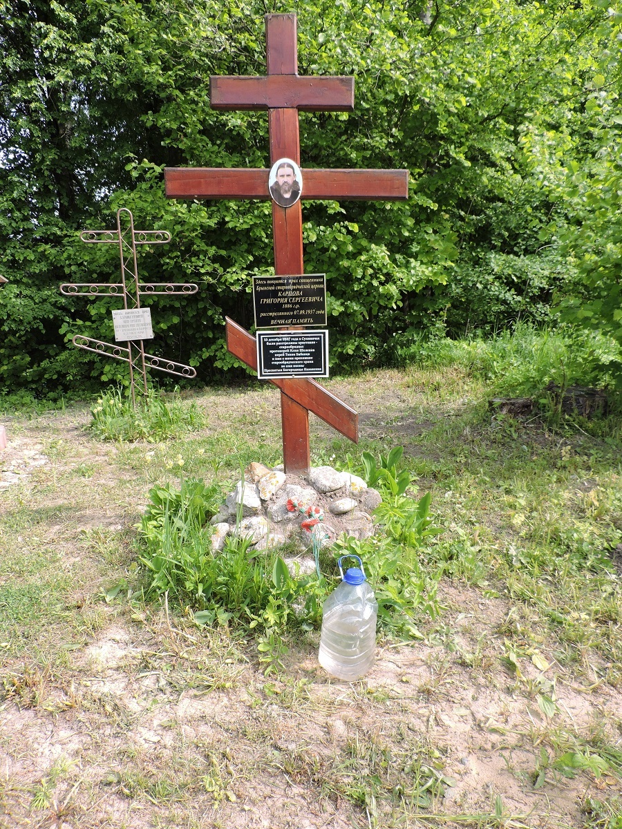 Крест о. Григорию Карпову. Вандалы оставили возле него бутыль с неизвестным содержимым